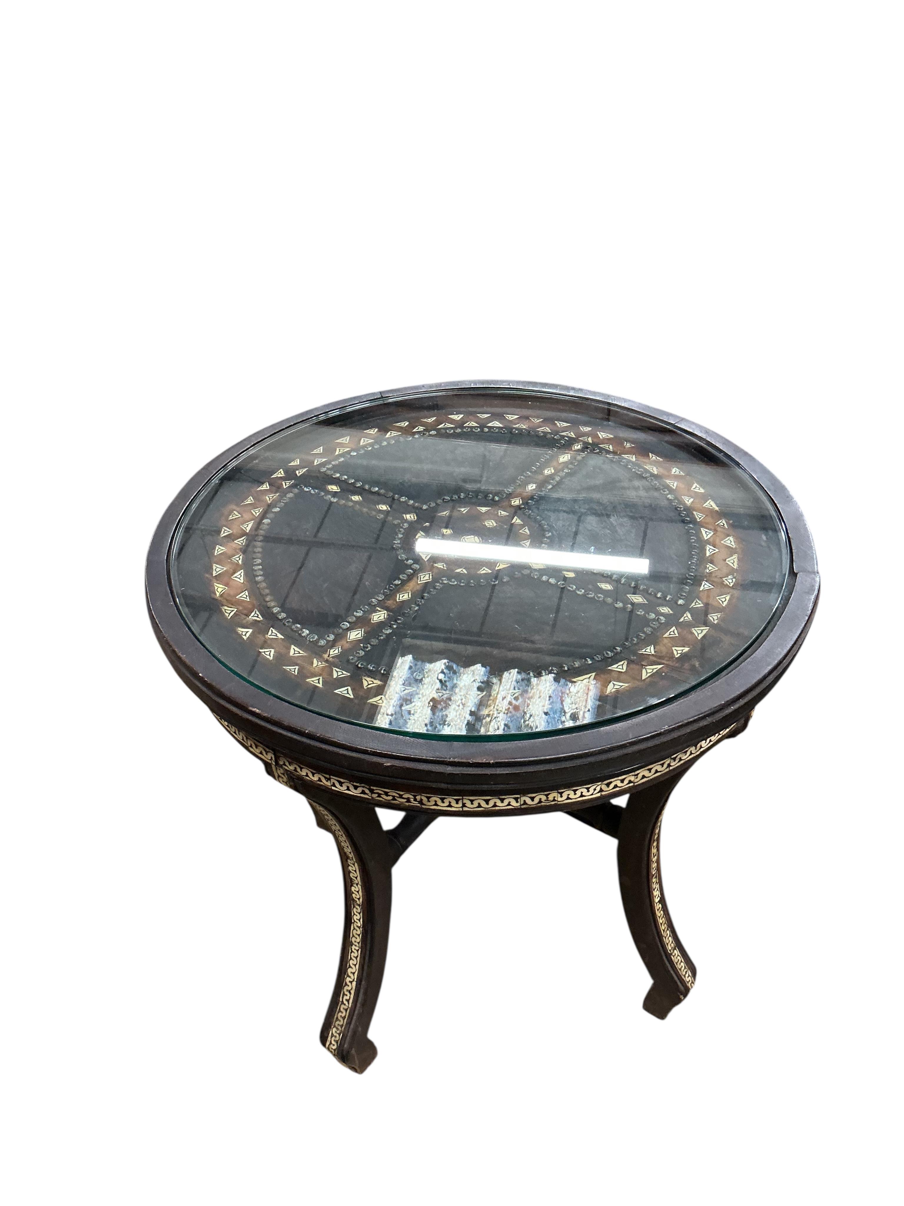 A Moroccan circular studded cedar glass top bistro table, diameter 80cm, height 76cm together with two matching chairs